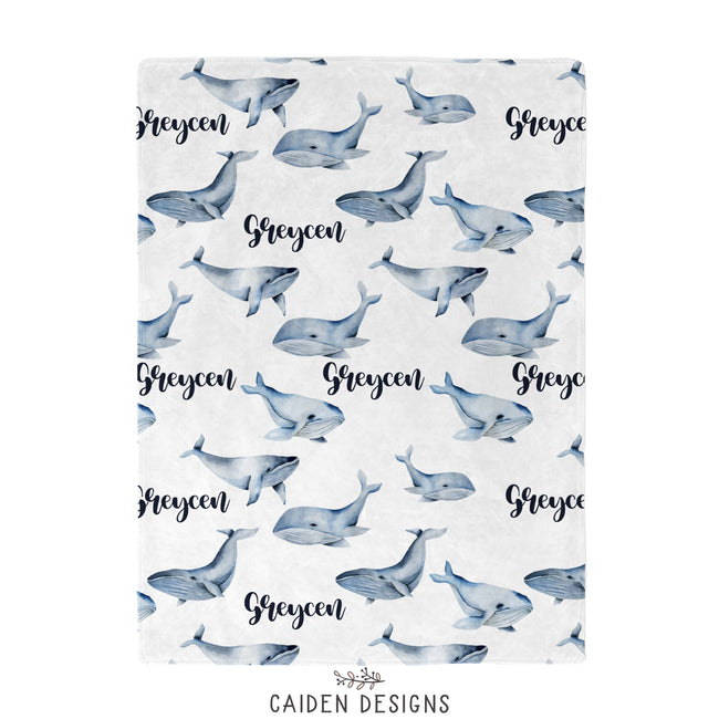 A blue and white whales baby blanket personalized with the name Greycen