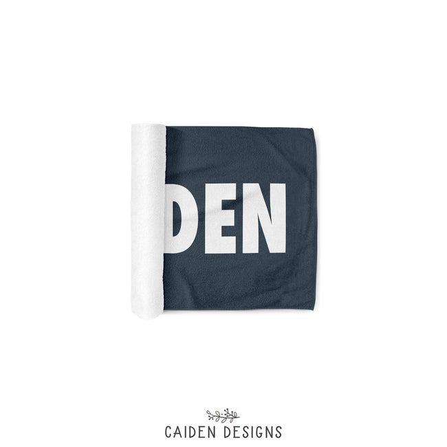 a partially rolled personalized beach towel in navy