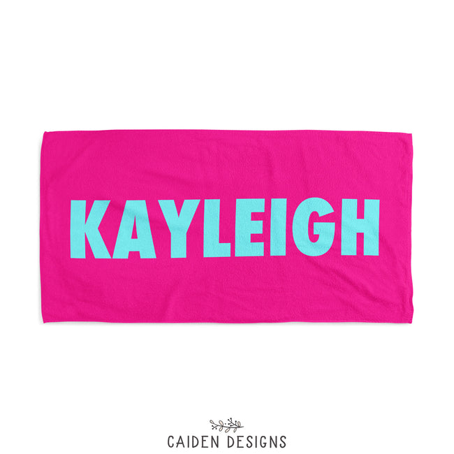 a personalized beach towel in hot pink with name Kayleigh on it