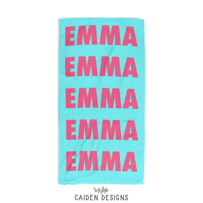 An aqua personalized beach towel with the name Emma in hot pink