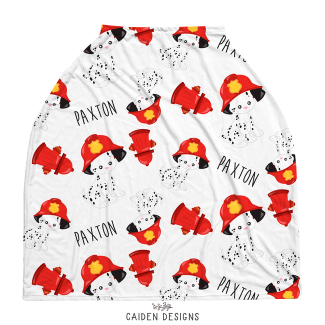 A multicolored personalized baby car seat cover featuring a pattern of dalmatians in firefighter gear on a white background, with a tapered shape and a 1/2" seam.