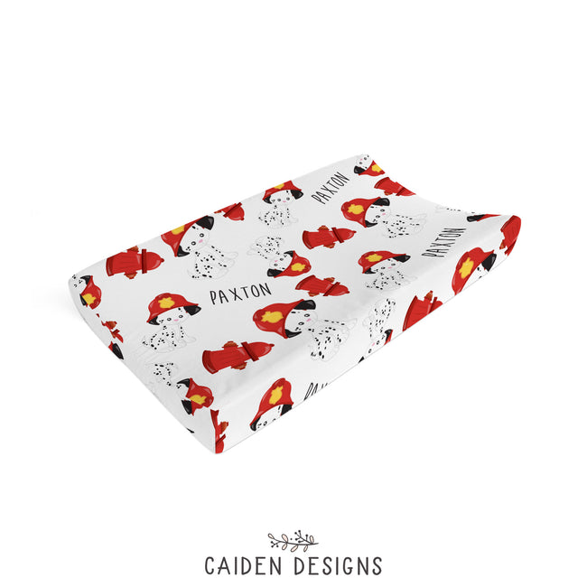 A personalized changing pad cover with a Dalmatian firefighter design, featuring the name 'Paxton'.