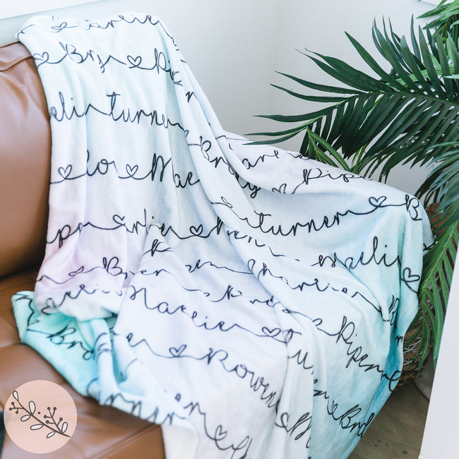 Personalized blanket with a pastel ombre pattern and repeated names on it.