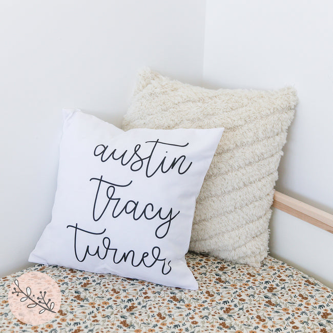 A personalized throw pillow with family names printed on it