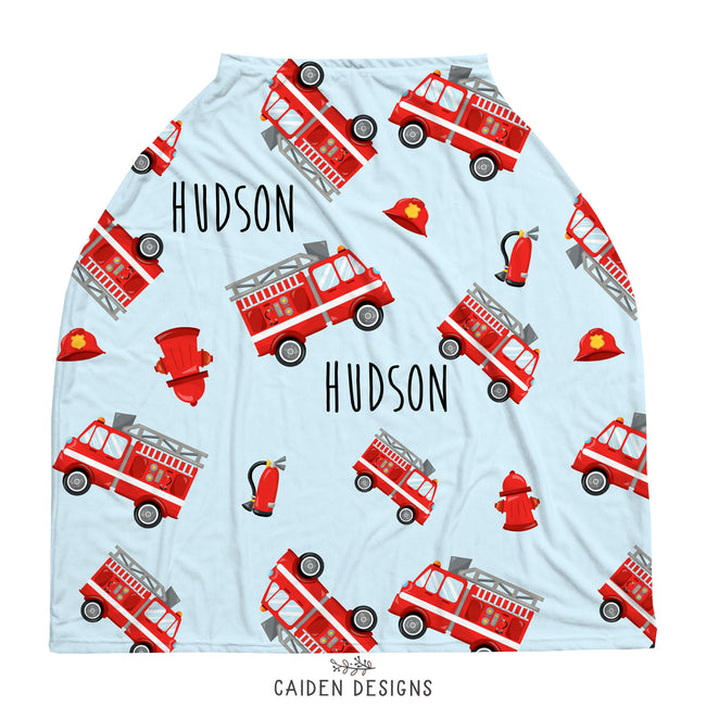 A personalized baby car seat cover featuring red fire trucks on a light blue background 
