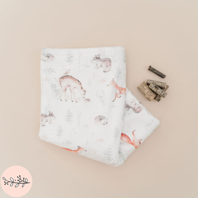 A personalized baby blanket with a pattern of woodland animals 