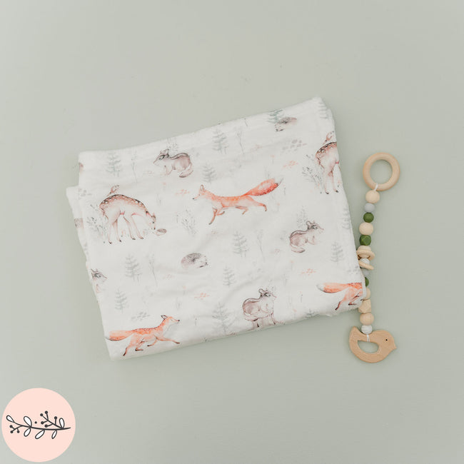 A personalized baby blanket with a pattern of woodland animals 