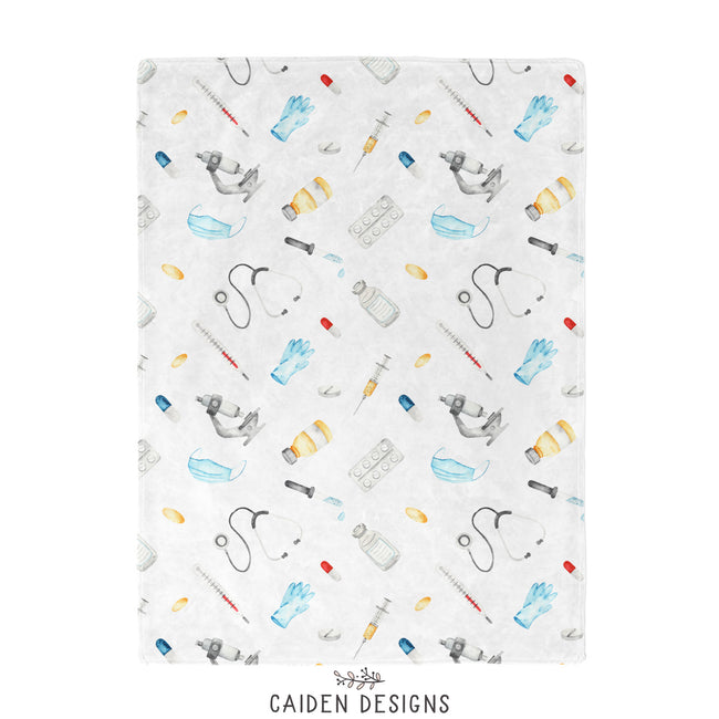 A baby with a medical themed baby blanket