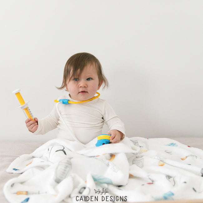 A baby with a medical themed personalized baby blanket