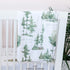 a forest personalized baby blanket wrapped over a crib