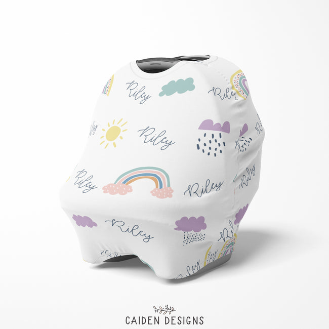 A multi-use baby car seat cover with a white background featuring colorful rainbow and cloud illustrations, with the name 'Riley' prominently displayed.