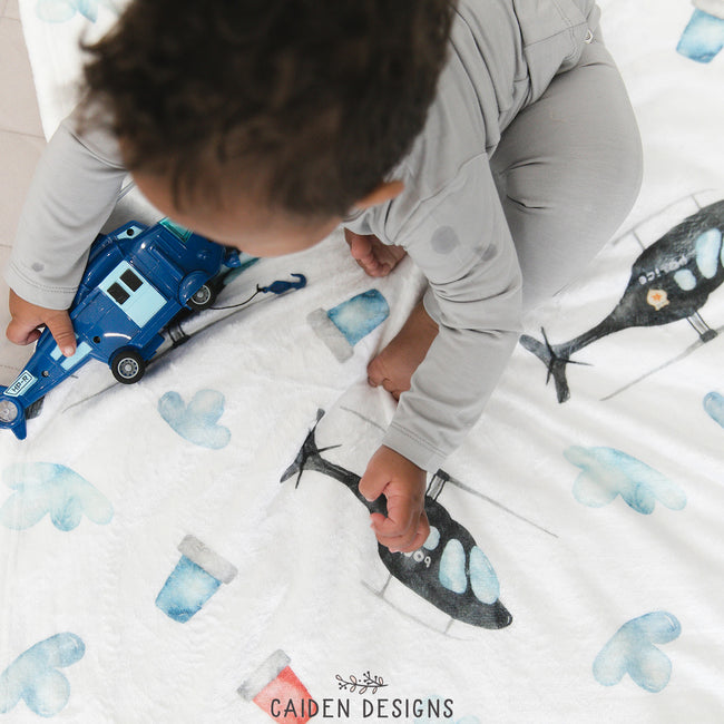 A boy playing on a helicopter themed personalized blanket