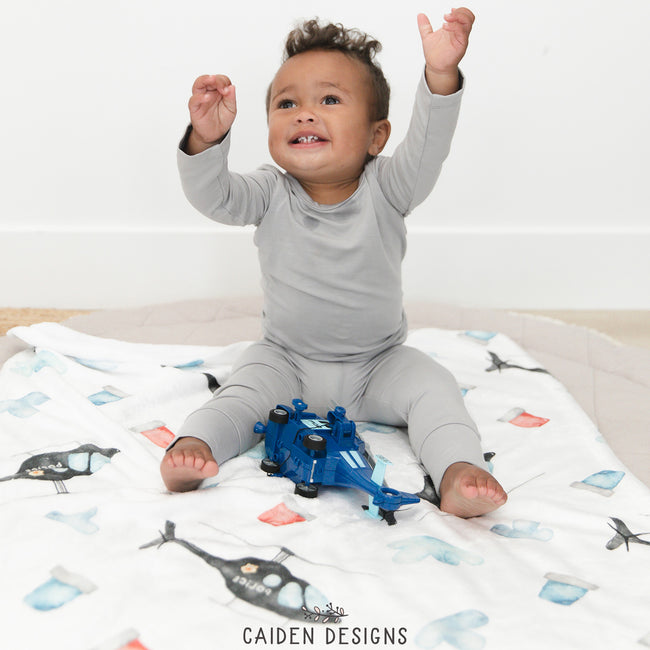 A boy playing on a helicopter themed personalized blanket