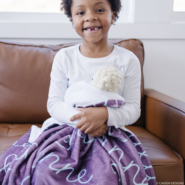 Little girl with a plum personalized blanket on her lap