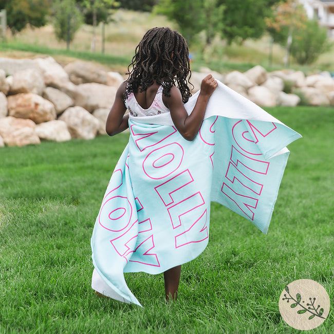A little girl with an aqua personalized beach towel