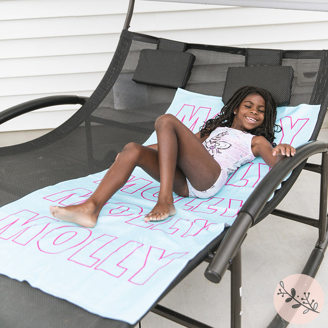 A little girl with an aqua personalized beach towel