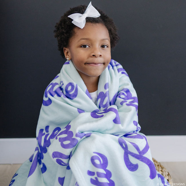 Girl with a soft mint personalized blanket for kids with purple name on it
