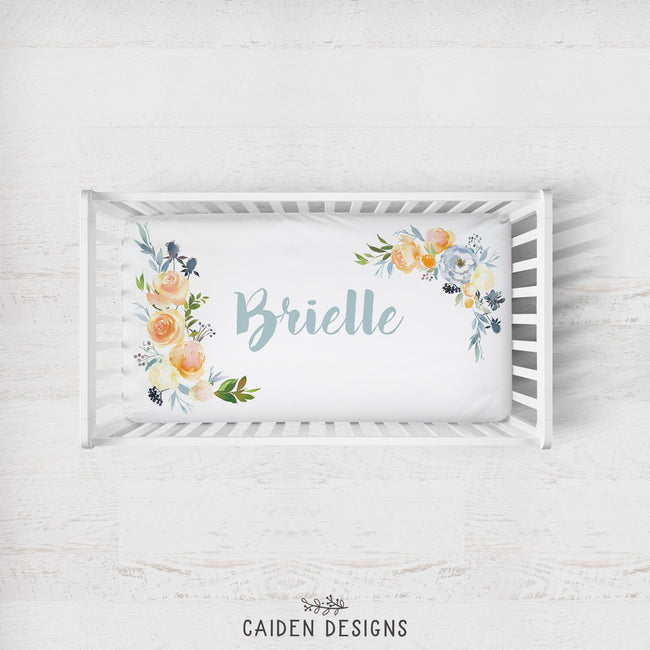 A crib sheet with a floral pattern and the name 'Brielle' printed on it.