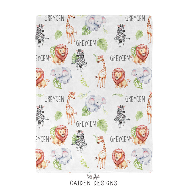 A personalized white blanket featuring repeated watercolor giraffe, elephant, lion, zebra and plants with the name "GREYCEN" in black, capitalized letters. 