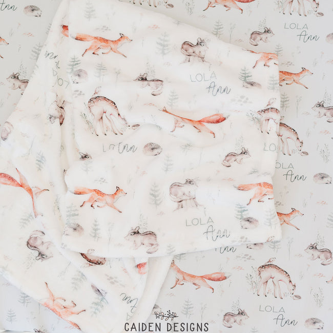 A personalized baby blanket with a pattern of woodland animals 